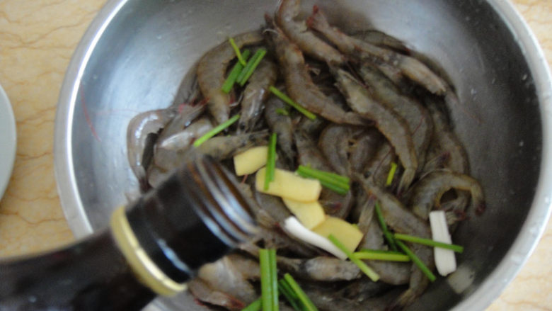 油爆虾,先用料酒,葱段和生姜片把虾腌制20分钟去腥