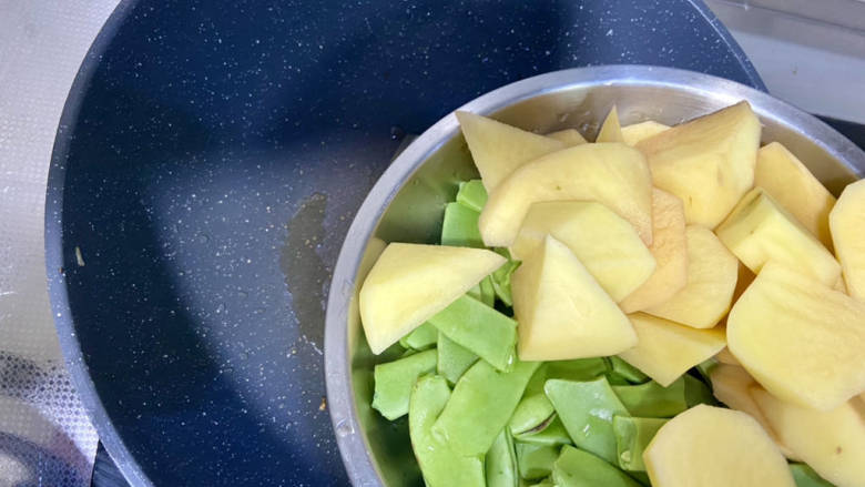 排骨土豆炖豆角,炒锅烧热,加少许食用油,加入土豆豆角中火翻炒到豆角变绿犯青,盛出