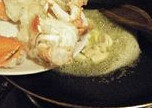 黑椒牛油炒蟹,锅烧热后,放牛油煮融,爆香姜片和大蒜,加入蟹肉翻炒均匀