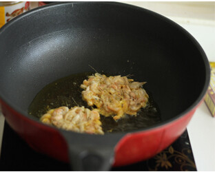 黑椒酥虾饼 ,锅内倒油，烧6成热，用汤勺舀入一勺搅拌好的小虾，放入锅内，按压成饼型，中火煎炸至两面金黄酥脆即可