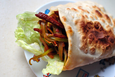 干煸牛肉丝口袋烙饼,取出烙好饼,将之前炒好的干煸牛肉丝和球生菜叶,塞进开口!趁热享用啦!