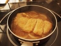 猪排丼,取一个小锅子(用小锅子刚好一人份,如果人多,可以用大的平底锅,一下子做多份),锅子里面放入柴鱼汤(昆布放水里浸一晚上最好,然后放入柴鱼一起煮开晾凉就可以了)、切条的<a style='color:red;display:inline-block;' href='/shicai/ 29'>洋葱</a>,一勺味啉,一勺砂糖,一勺生抽,开火煮,这个时间把炸好的猪排切块,等汤有点煮开的时候把猪排放进去煮一会儿让猪排吸饱汤汁。