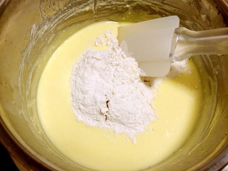 轻乳酪蛋糕,低筋面粉过筛加入奶酪溶液里,用刮刀翻拌。