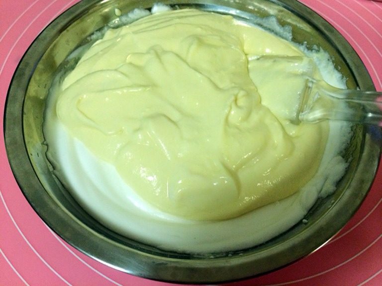 轻乳酪蛋糕,取三分之一奶酪糊加进蛋白,用橡皮刮刀翻拌。翻拌是从底部铲上来,分别往左右拌匀。不能朝同一方向搅拌,蛋白会消泡,影响蛋糕口感。
