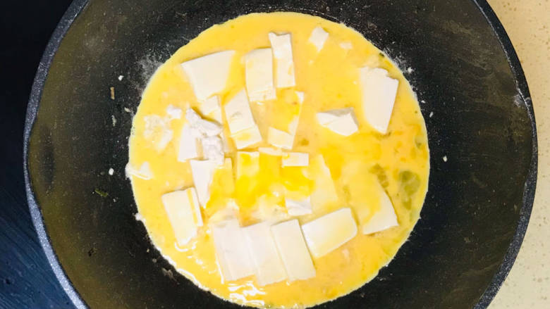 鸡蛋炖豆腐,倒入鸡蛋液,继续慢火煎至凝固