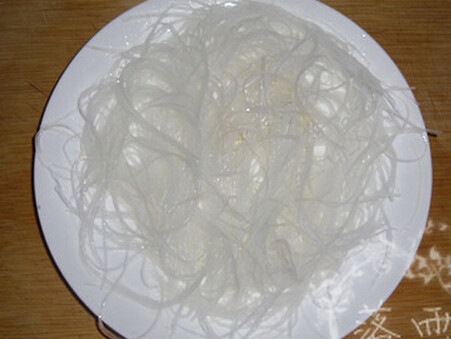 金针粉丝蒸虾仁,将粉丝沥下水剪成对半铺在盘底