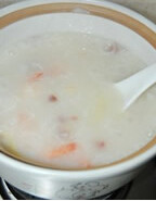 火腿鲜虾粥,加入<a style='color:red;display:inline-block;' href='/shicai/ 846'>色拉油</a>，搅匀，再加入姜丝和虾，加盐调味，虾变色即可出锅，吃的时候撒入葱末即可