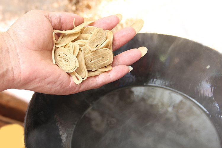 客家菜 香炸鱼丝脆,开小火，抓一把客家鱼丝，量不用太多，直接放入油锅中。