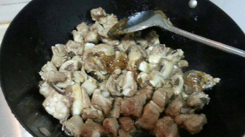 糖醋排骨,把火调到中档后放入待用的排骨，炒出糖色。