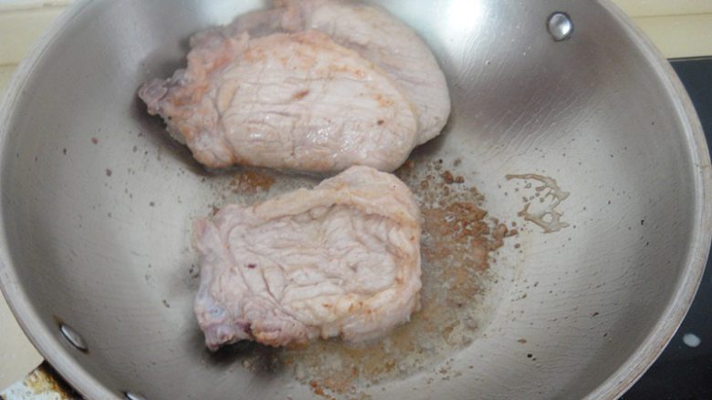 葱烧大排,热锅温油猪排逐片下入煎至变色马上翻面,两面变色后推向一边,至煎完排骨