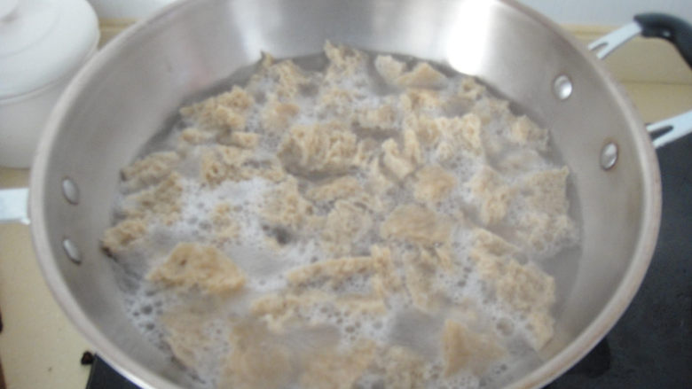 手撕烤麸,烤麸冷水下锅盖上大火烧开2分钟后捞起,用清水不断的冲洗挤压,把里面的酸水全部冲洗干净为止