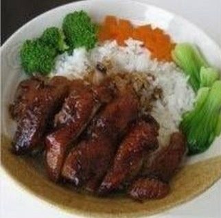 照烧鸡肉饭,米饭盛入碗内,将鸡腿肉和各种蔬菜摆在米饭上,淋上浓稠的照烧汤汁即可。