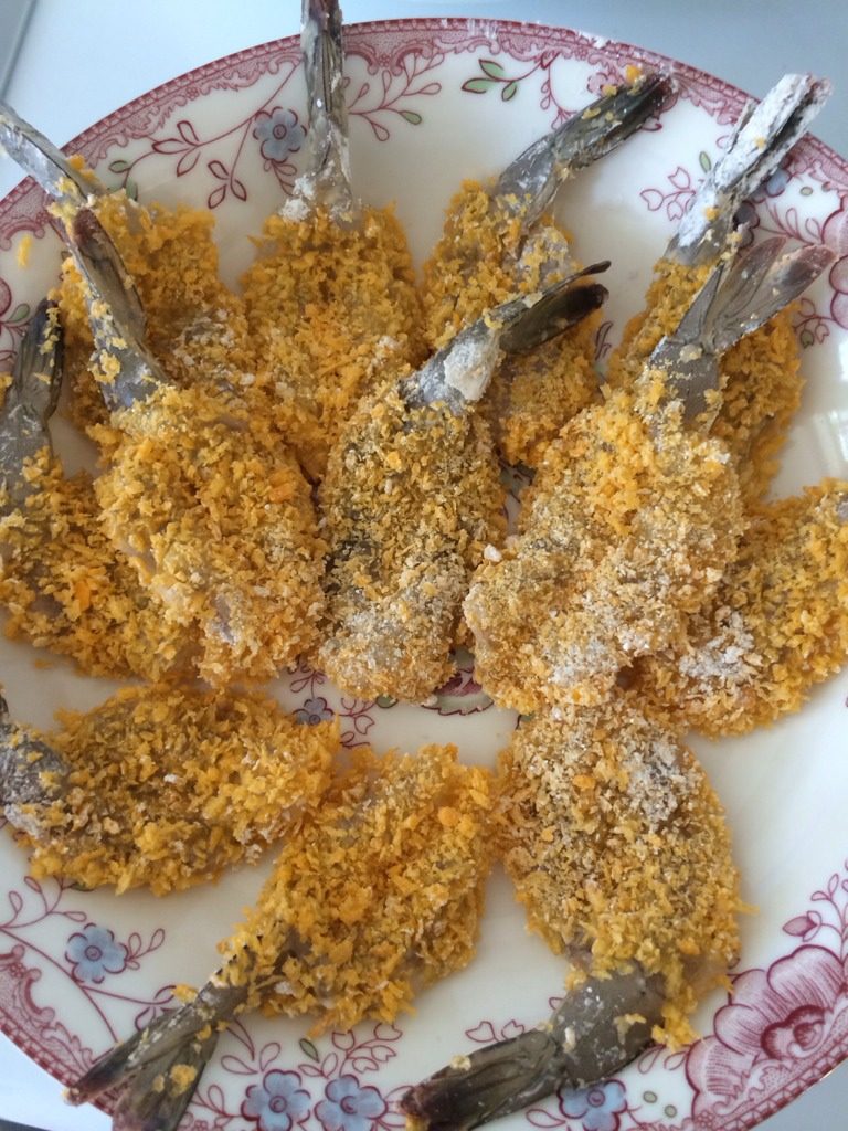 炸虾排,如图把腌制好的虾排依次先沾一层淀粉,在裹上鸡蛋液,然后在沾上面包糠。