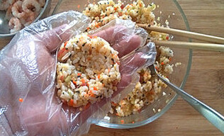 紫菜饭团子,取饭团放入手心中,借助小勺在米饭的中间压一个窝