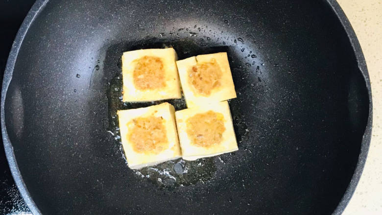 煎酿豆腐,锅里加油,烧热,加入豆腐块,慢火煎至四面金黄色