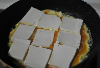 鸡蛋肉沫盖豆腐 ,鸡蛋底部凝固得差不多了,将豆腐片摆到未凝固的鸡蛋夜上
