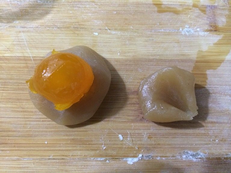 广式月饼,把莲蓉均匀包裹在蛋黄外侧