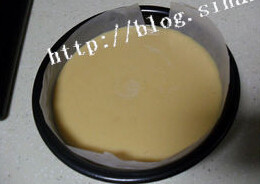 奶油焦糖乳酪蛋糕,低筋面粉过筛,拌成奶油面糊,倒入铺上烘焙纸的模具中,在桌子上轻敲几下,表面抹平