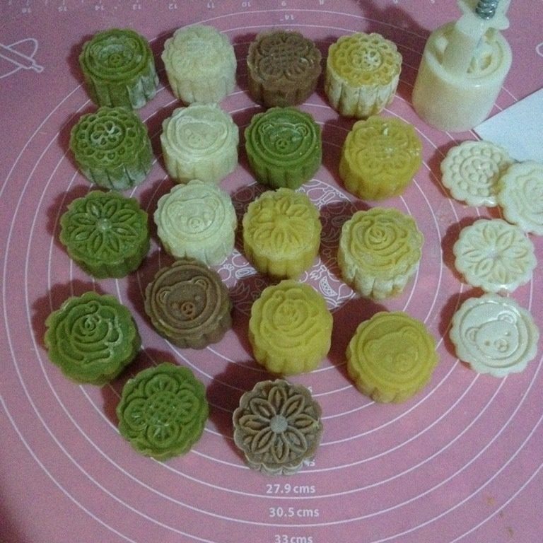 奶黄冰皮月饼,模具里撒点糕粉,再把多余的粉倒出来,放入包好的月饼胚压出花纹即可