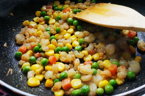 小熊睡眠炒饭,油锅倒入虾仁大火快速翻炒变色后倒入综合蔬菜粒翻炒片刻