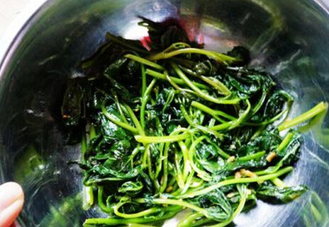 红油嫩虾滑,将炒好的红薯尖，铺在盆子底备用
