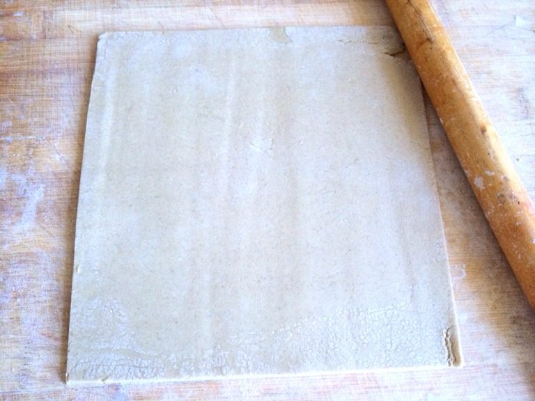 小当家油麦面条,案板上撒一层薄面防粘,取出油麦面团用擀面杖擀平