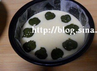 抹茶卡门贝尔乳酪蛋糕 ,在模具上抹上色拉油,铺上烘焙纸,倒入奶酪糊,在奶酪糊中滴入抹茶糊,用牙签画出想要的形状