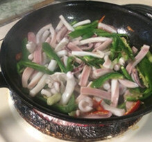 孜然青椒炒鱿鱼,油锅下姜丝爆香后加入青红辣椒，鱿鱼翻炒