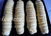 奶酪鳜鱼面包 ,烤箱预热200度,在发酵好的面包生坯表面刷蛋液,将烤盘放入预热好的烤箱中层,烤制20分钟即可