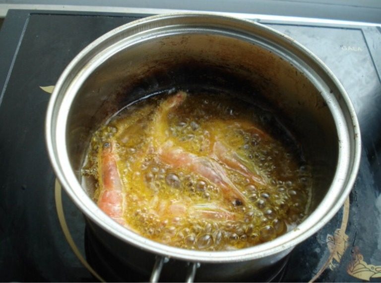 超简单版【黑椒酥炸虾】,中火，油烧成6成热，你就理解为烧成不那么热吧，把虾放进去，转大火炸，这时候不要动，因为淀粉容易散。炸至表面金黄时捞出晾晾后再次入锅炸30秒即可酥脆出锅