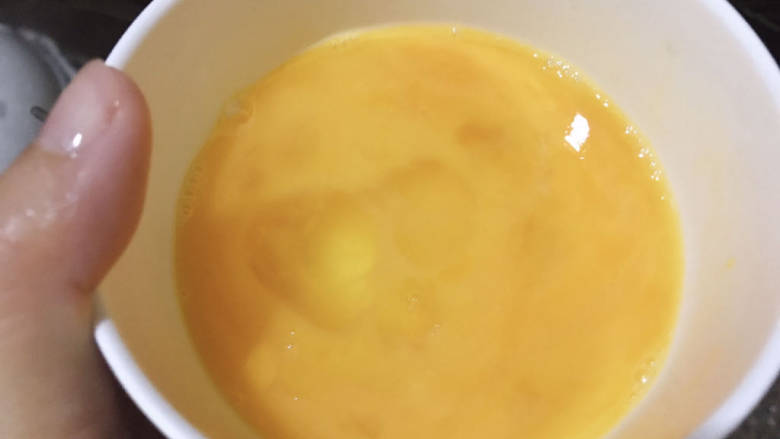 包菜胡萝卜炒鸡蛋,碗中打入两个鸡蛋,加适量盐打散