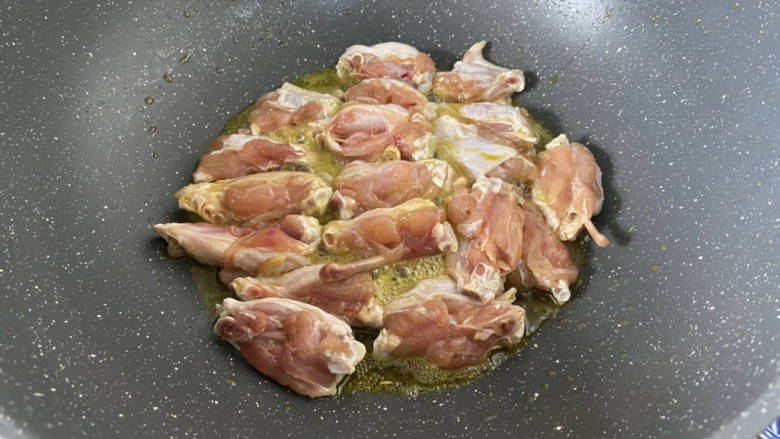 蒜香焖翅,腌制好的鸡翅,鳙厨房纸巾吸干水分,锅中加蒜油,加入鸡翅,中小火加盖焖煎,让蒜香味融入鸡翅