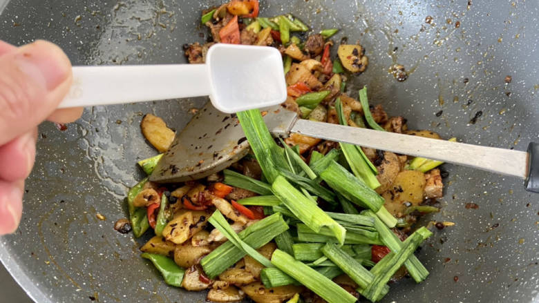 土豆回锅肉,加入<a style='color:red;display:inline-block;' href='/shicai/ 3349'>蒜苗</a>蒜叶和一点食盐,翻炒均匀