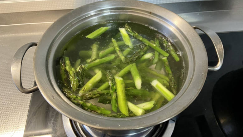 鸡胸肉蔬菜沙拉,坐锅烧水,水开加几滴食用油少许食盐,下芦笋烫2分钟捞出备用