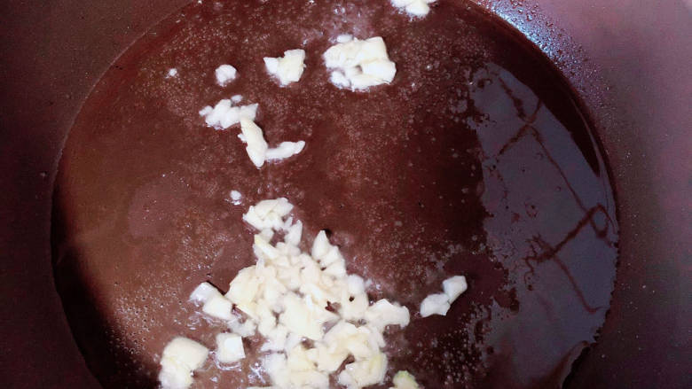 番茄藕丁,锅中倒入油,加热至五成热,放入蒜末爆香。