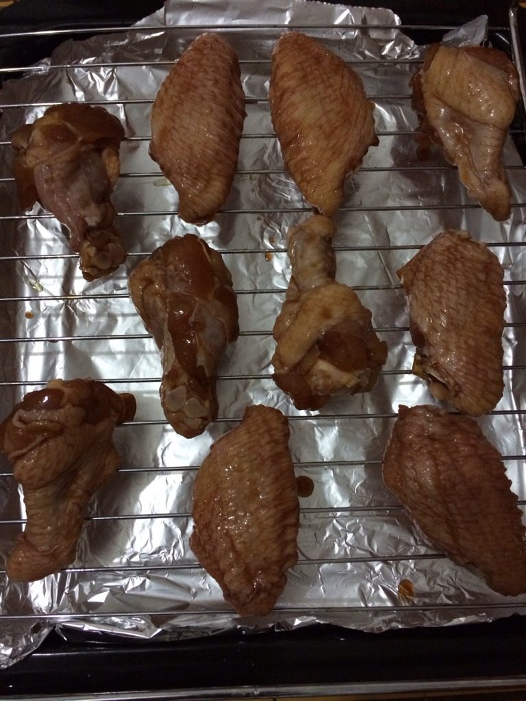 烤翅,烤盘上铺上一层锡箔纸，这样可以接住一会烤的汁方便清洗。烤架上刷一层油，防止粘住。如图摆好