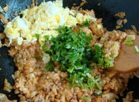韩国辣白菜炒饭,加入米饭翻炒，最后加入香菜和炒熟的鸡蛋翻炒均匀即可，装盘开吃