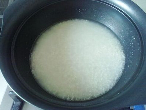 豉香辣翅煲仔饭,煲仔锅底刷少许食用油，将洗干净且泡水1小时的米倒入煲仔