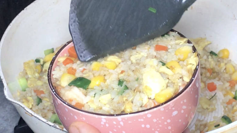玉米虾仁蛋炒饭,装入小碗中,压实