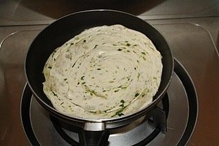 千层手抓饼,如图小火加热。平底锅中倒入少许油,晃动锅子让油均匀的铺满锅底,然后将饼胚放进锅中,中小火煎,煎至晃动锅子时,饼在锅中自由移动时,翻面继续煎至两面金黄,即可出锅