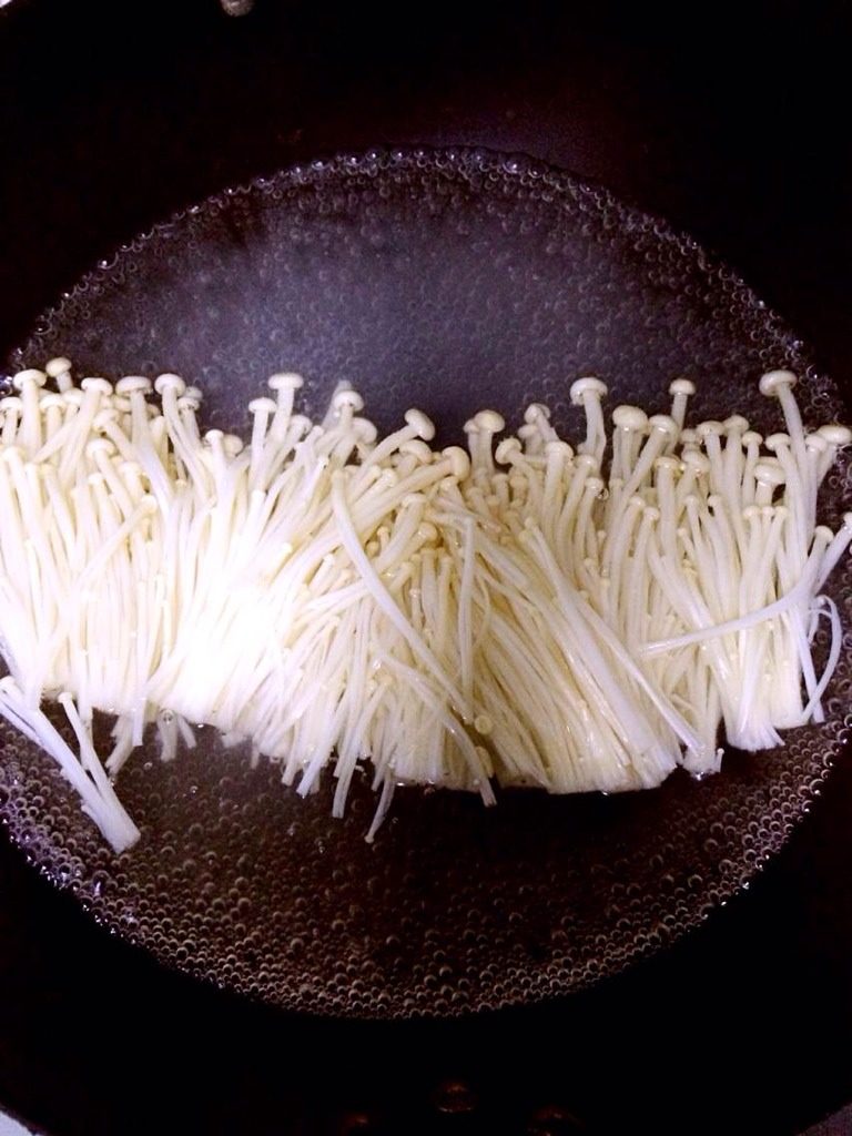 金针菇培根卷,水开后加点食盐放入金针菇焯水捞起。