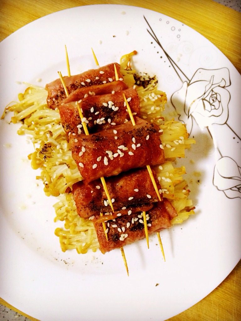 金针菇培根卷,放入锅内少许油小火慢煎至二面金黄。出锅后可按照个人口味撒料。我做的是<a style='color:red;display:inline-block;' href='/shicai/ 134333'>黑胡椒</a>口味！加了点白芝麻好看！