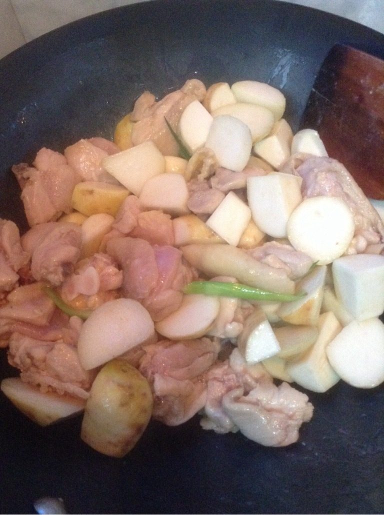 乳香琵琶腿芋艿煲,葱姜蒜炝锅,倒入炒好的芋头和鸡肉,继续翻炒。