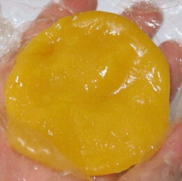 芒果糯米糍,取一小块糯米团，放在保鲜袋上压扁