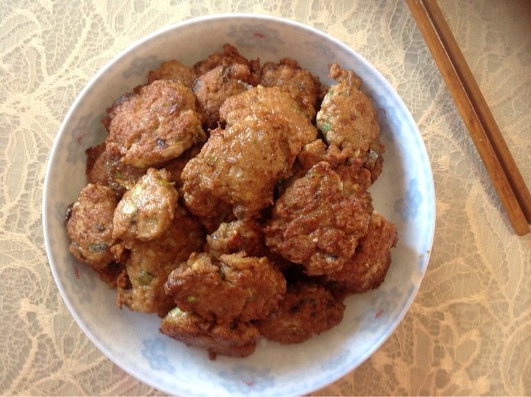 鲅鱼丸子,最后在锅里加油把丸子煎一下大概五六成熟就行,再加入清水(不要加太多,跟丸子高度平齐就行)慢火炖一会儿(大概15到20分钟),就可以关火盛盘了。