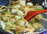 黄花芡粉肉,转小火，用手抓拌好的芡粉肉下入锅中