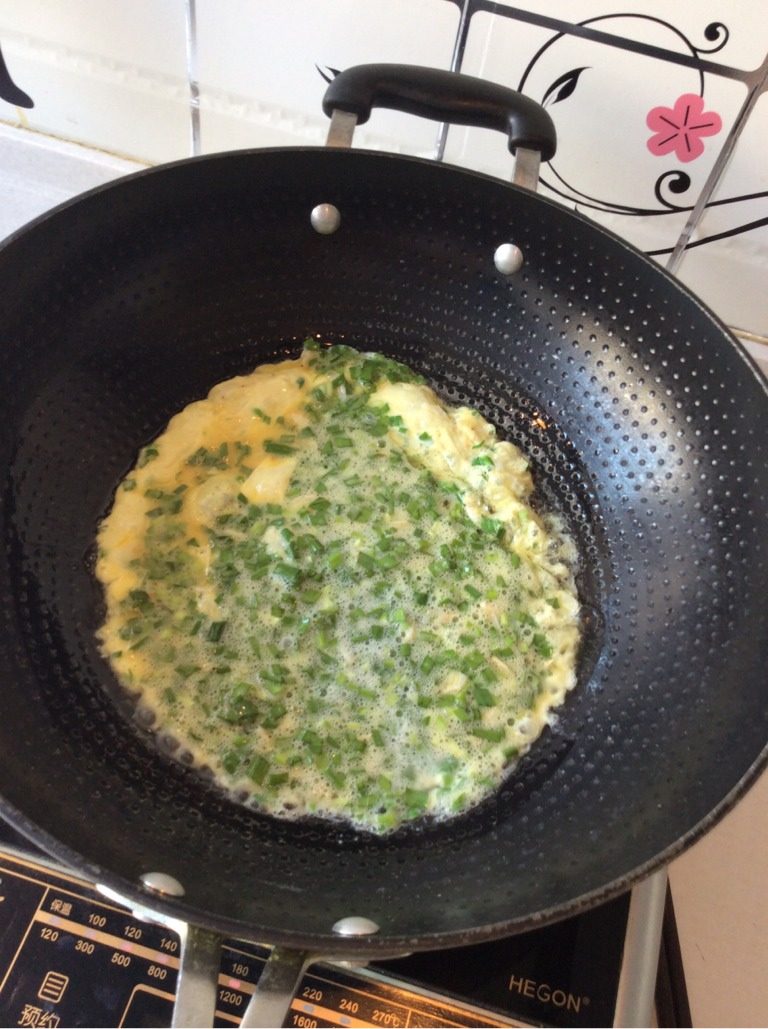 虾皮韭菜末炒鸡蛋,如图锅中放油，油热加入拌好的虾皮韭菜末鸡蛋液