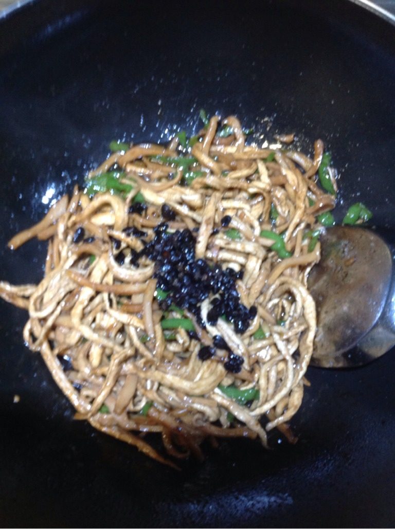 干萝卜条炒墨鱼丝,最后浇上豆豉汁,用中火不停翻炒,避免菜品粘锅,当闻到豆豉的香味后,可关火将菜盛盘