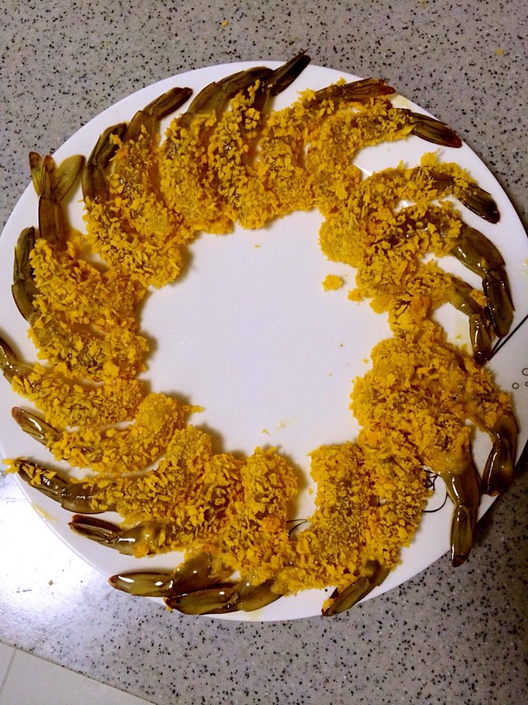 黄金虾球,拿好虾尾巴在盘里面打个滚，裹上面包糠。