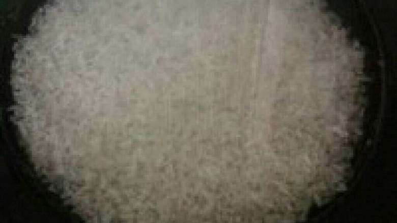 腊肉煲仔饭,在电饭锅锅底摸薄薄的一层油，放入洗好的米和水。